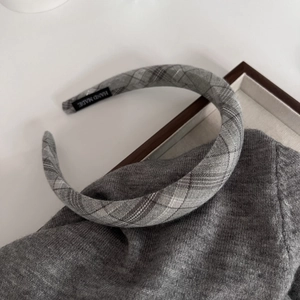 Detail of grey plaid padded headband showing handmade label on a soft textured fabric