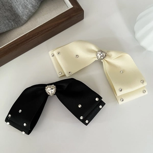 Elegant bow hair clips with heart-shaped rhinestones in cream white and black finishes