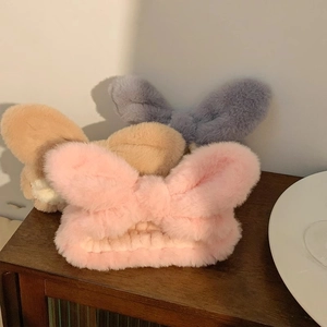 Detailed view of plush coral fleece bow headbands in pink, khaki, and grey colors