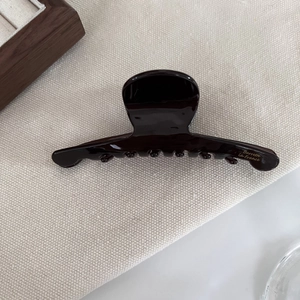 Detail showing deep brown acetate hair claw with golden Barrette La France lettering