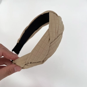 Détail du serre-tête torsadé à carreaux kaki montrant la texture et la doublure