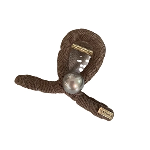 Brown knitted hair claw clip with pearl and golden LOVEDAYS metal tag on white background