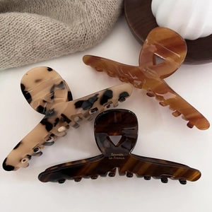 Close-up of French acetate hair claws with Barrette la France golden logo in various patterns