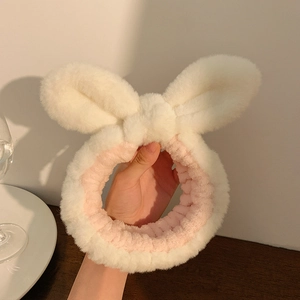 Detail showing the soft plush texture of white and pink rabbit ear headband for skincare
