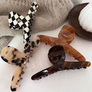 French style acetate claw clips set in check, leopard, and amber patterns on a tray