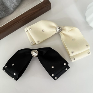 Detailed macro view of heart-shaped crystal on elegant silk bow hair clips