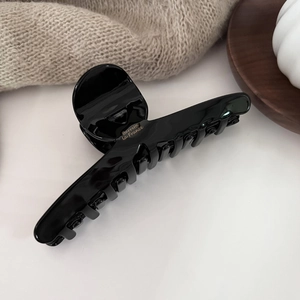 Close-up of black acetate hair claw with gold Barrette La France lettering text