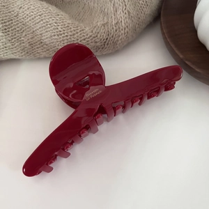Macro detail of wine red acetate hair claw clip with golden Barrette La France text