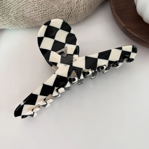 Macro shot of checkered acetic acid hair claw with golden Barrette La France engraving