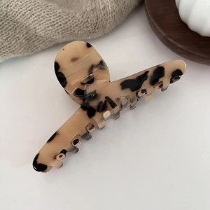 Close-up of tortoise shell pattern acetate hair claw clip with a strong silver metal spring
