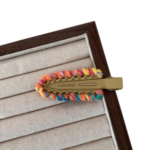 Knitted wool hair clip with colorful contrast weave on an olive green metal duckbill base