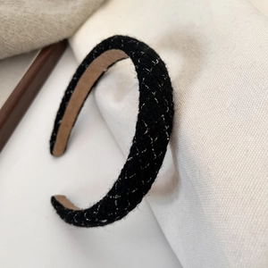 Close-up of black tweed headband with gold and silver plaid pattern and anti-slip lining