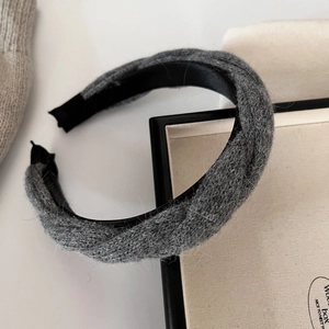 Gros plan d'un serre-tête en maille torsadée grise avec texture douce et doublure noire