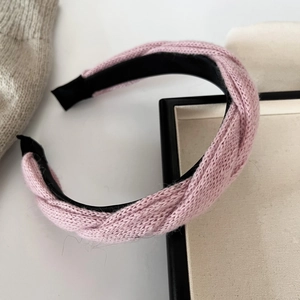 Détail d'un bandeau en maille rose avec motif torsadé et doublure intérieure noire
