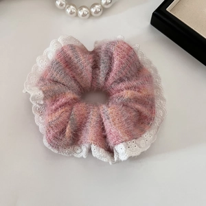 Dettaglio dell'elastico in peluche a righe rosa con bordo in pizzo bianco decorativo