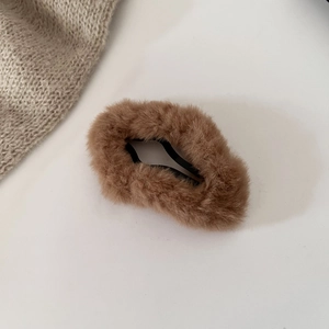 Close-up of soft brown plush faux fur cloud hair clip on a clean white background