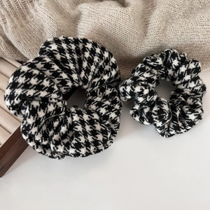 Classic black and white houndstooth hair scrunchies set on elegant knit background