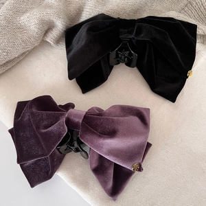 Elegant velvet bow hair claws in black and deep purple with golden logo details