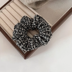 Close-up of vintage black and white houndstooth tweed scrunchie with soft fabric texture
