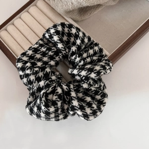 Close-up of black and white houndstooth hair scrunchie with thick wool texture