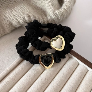 Set of two black scrunchies featuring elegant gold-framed heart pendants with enamel inlay