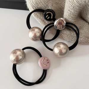 Détail d'élastiques à cheveux perle sourire avec perles dorées et cordes élastiques