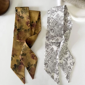 Detail of floral and rose print skinny scarves in ginger yellow and white silk fabric