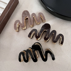Elegant wavy metal claw clips with acetate finish in pink, brown, and black colors