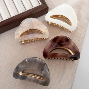 Set of four small acetate crescent hair claws in marble and tortoiseshell patterns