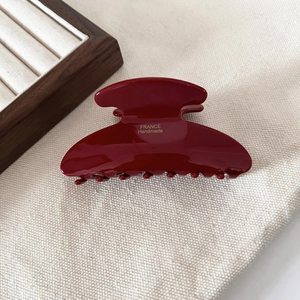 Macro view of high-gloss wine red hair claw clip with golden France Handmade text