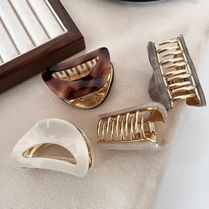 Set of four small crescent acetate hair claws in leopard and marble patterns for women