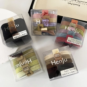 Detail of five colorful boxes featuring elastic hair ties and seamless ponytail holders