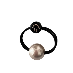 Élastique à cheveux avec perle et perle smiley sur un bandeau tissé noir minimaliste