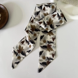 Detail of floral skinny silk scarf showing abstract print and smooth satin texture