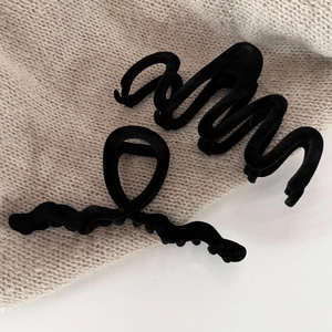 Close-up of black velvet pearl hair claw clips with wavy and minimalist geometric designs
