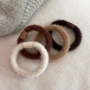 Lot de quatre chouchous en peluche douce aux tons marron avec étiquettes girl en cuir