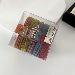Close-up of thick elastic seamless hair ties in assorted colors within a branded box