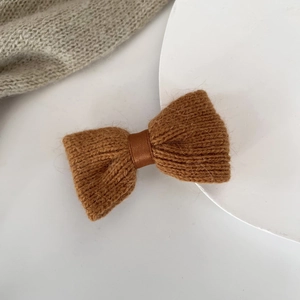 Detail of soft brown knitted bow hair clip with textured ribbed wool and satin ribbon