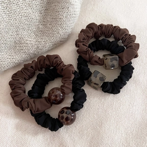 Set of 4 leopard print satin scrunchies in black and brown with geometric beads
