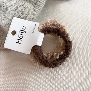 Detailed macro view of soft lamb wool hair ties set in beige and brown colors