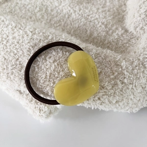 Detalle de goma para pelo con corazón amarillo y grabado France Handmade en tela