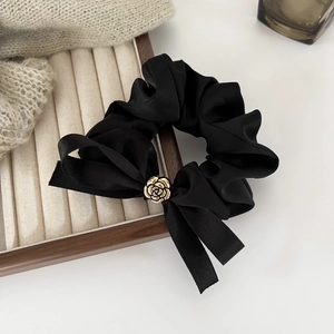 Chouchou élégant en satin noir avec nœud camélia et détail de fleur en métal doré