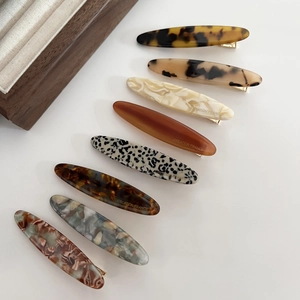 Detailed view of eight acetate hair clips featuring tortoiseshell and marble patterns