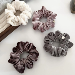 Luxury velvet hair scrunchies set in neutral tones with metallic gold emblem tag decoration