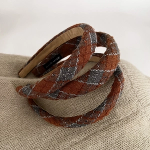 Detailed close-up of brown plaid tweed headband with a handmade textile label inside