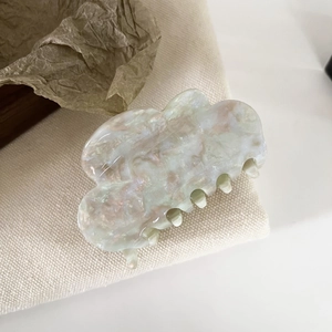 Detailed view of cloud-shaped acetate hair claw clip with pearlescent marble texture