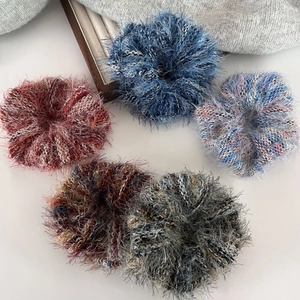 Dettaglio di cinque scrunchies in maglia soffice in colori pastello e filati misti