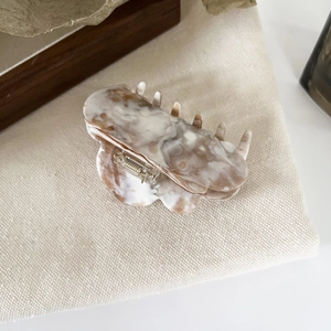 Detail of marble pattern acetate hair claw clip with silver spring and smooth teeth