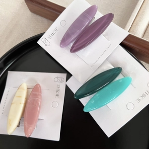 Minimalist oval hair clips set in colorful marbled resin on display card for women