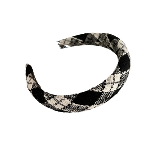 Classic black and white argyle tweed headband with vintage woven texture on white background